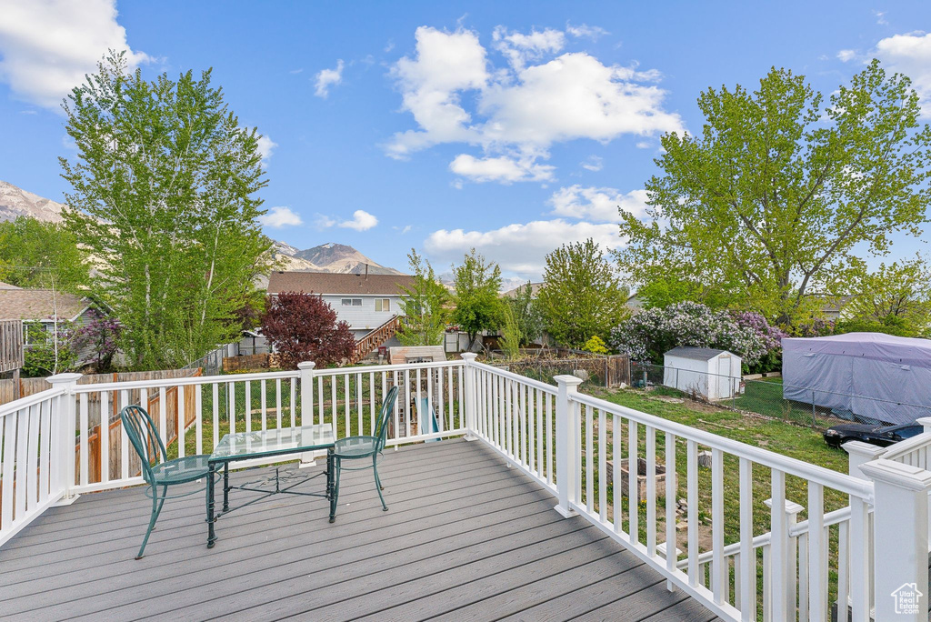 Wooden deck with a mountain view and a yard
