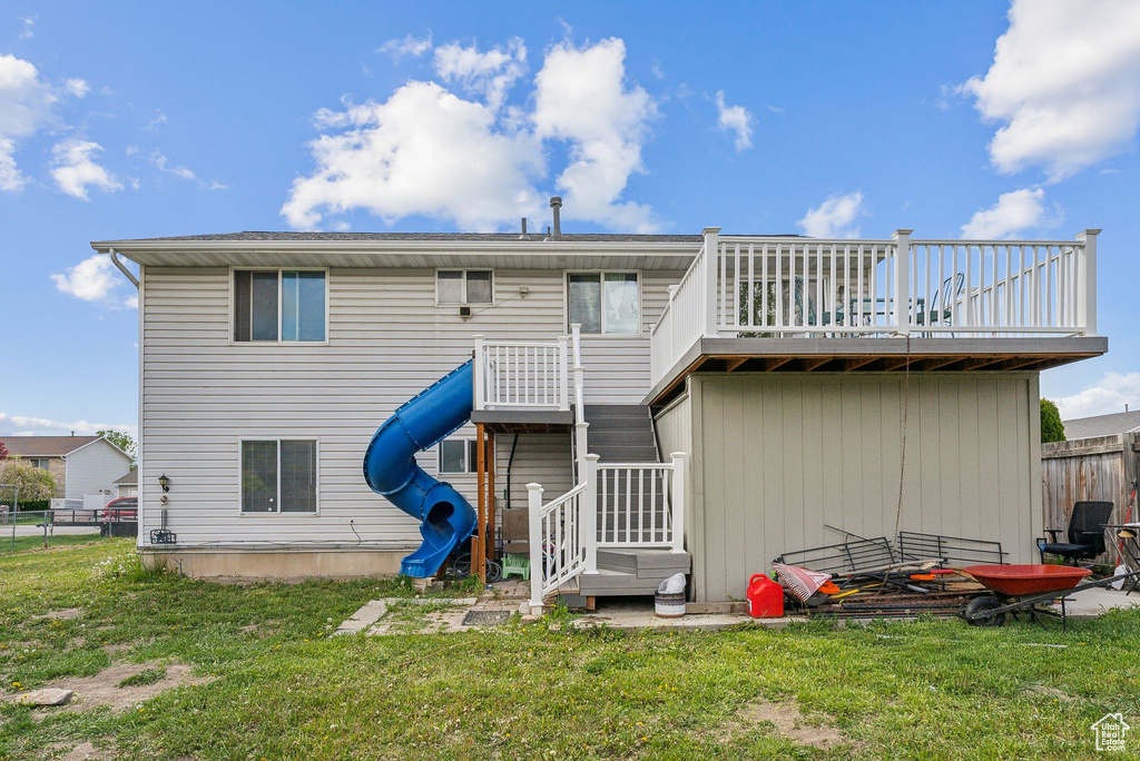 Back of property with fence and a yard