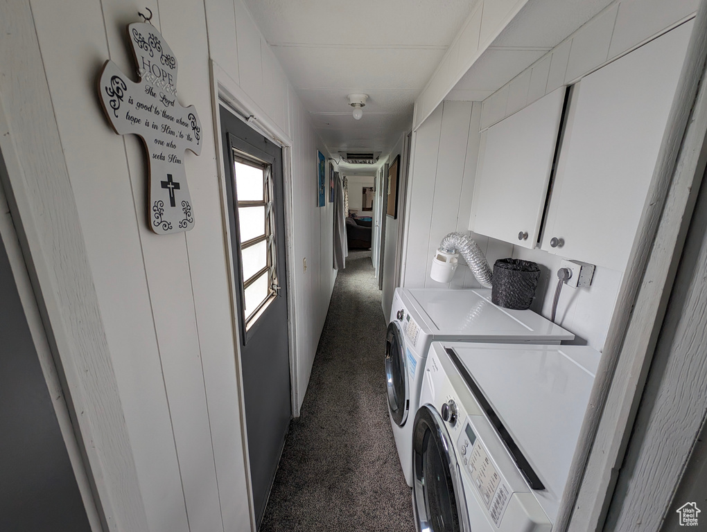 Clothes washing area with dark carpet, cabinet space, and independent washer and dryer