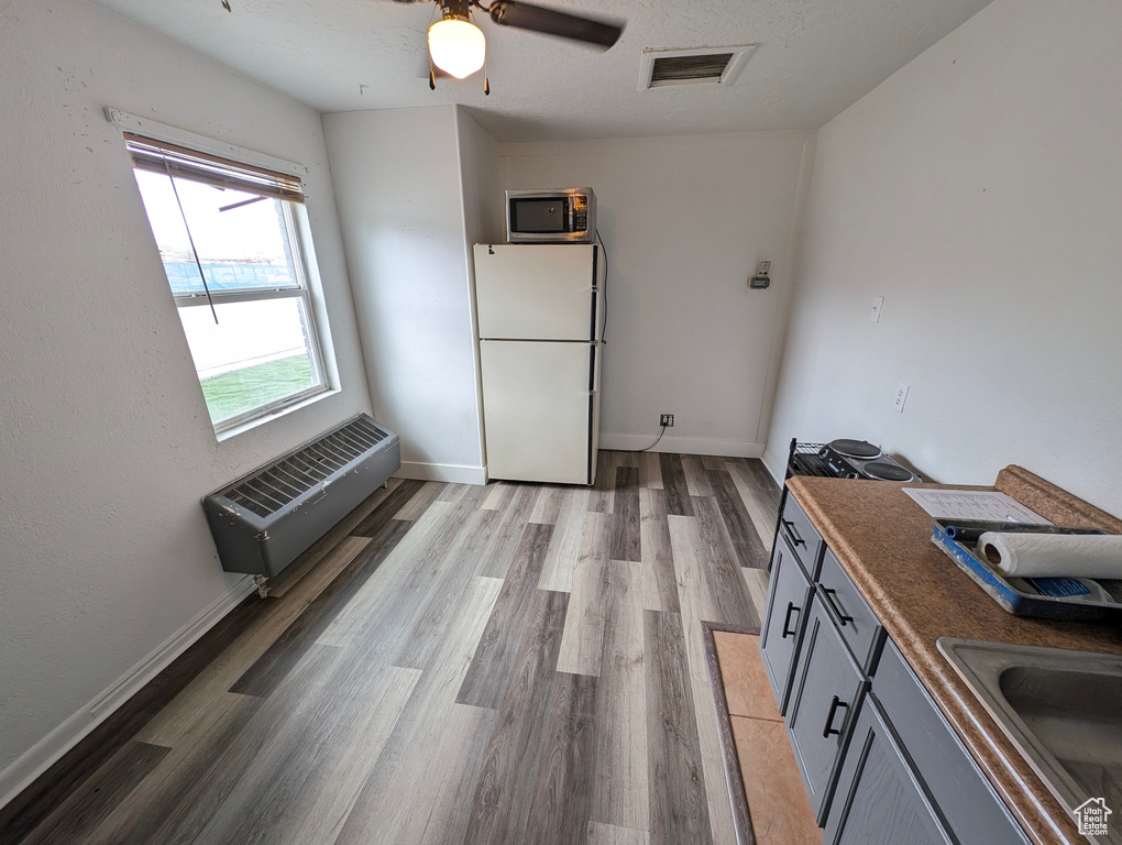 Unfurnished dining area with visible vents, a sink, plenty of natural light, and light wood-type flooring