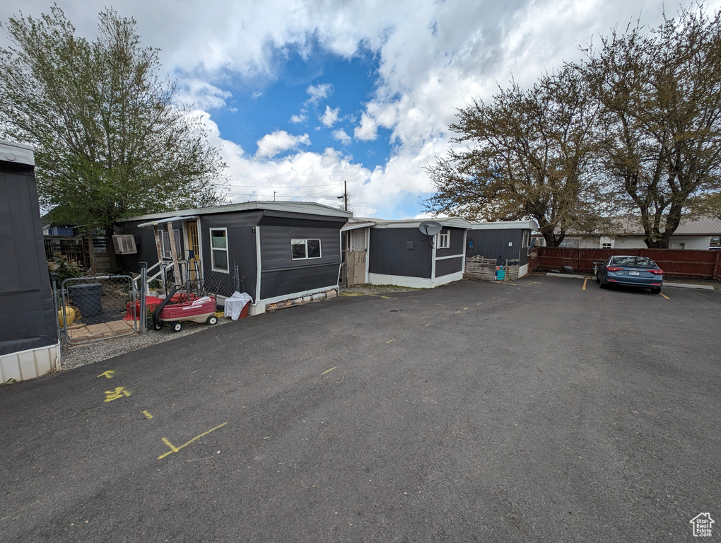Manufactured / mobile home featuring an outdoor structure, fence, and a shed