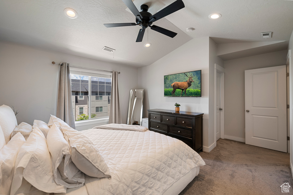 Bedroom with visible vents, carpet flooring, baseboards, and lofted ceiling