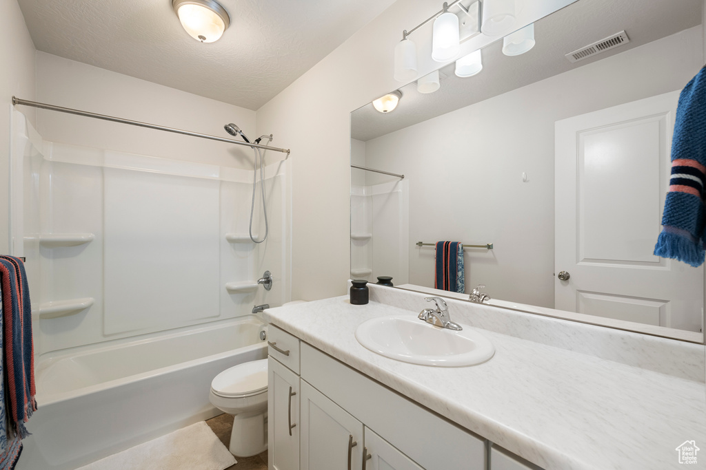 Bathroom featuring visible vents, bathtub / shower combination, vanity, tile patterned floors, and toilet