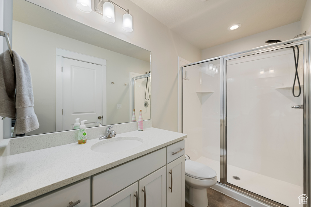 Bathroom with vanity, a shower stall, and toilet
