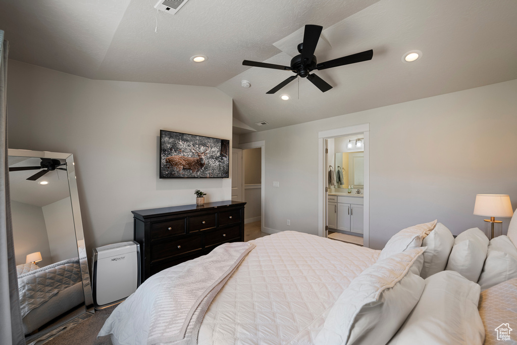 Bedroom with lofted ceiling, recessed lighting, ensuite bath, and visible vents