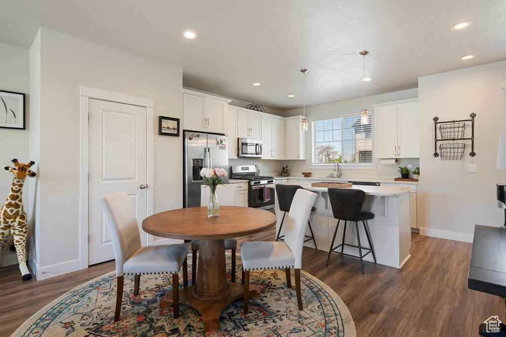 Dining room with recessed lighting, baseboards, and dark wood finished floors