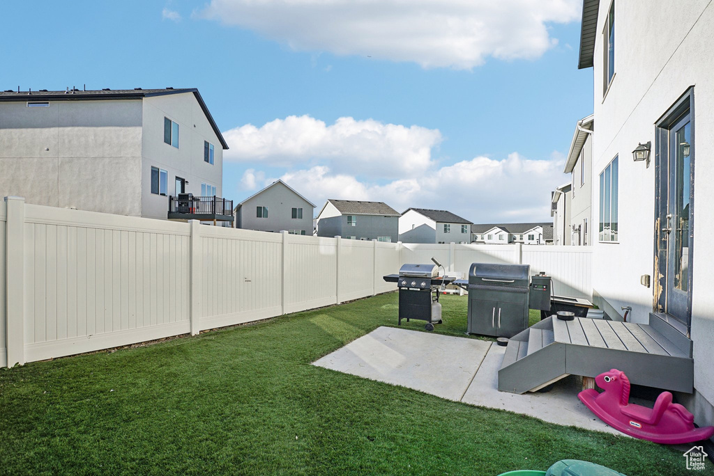 View of yard with a fenced backyard, a patio, and a residential view