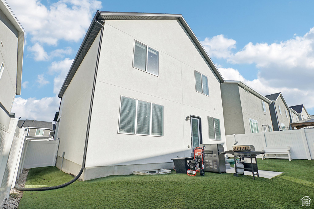 Back of house with a lawn, a fenced backyard, and stucco siding
