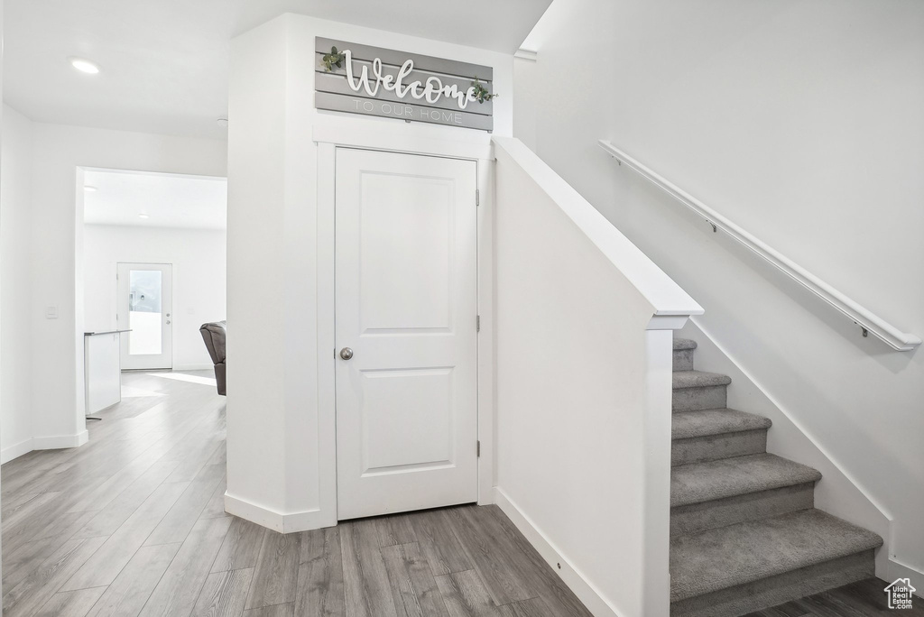 Stairs with baseboards, recessed lighting, and wood finished floors
