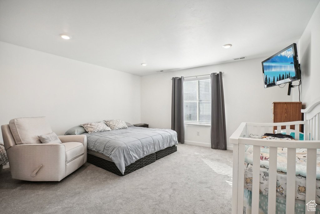 Bedroom with light carpet, recessed lighting, and visible vents