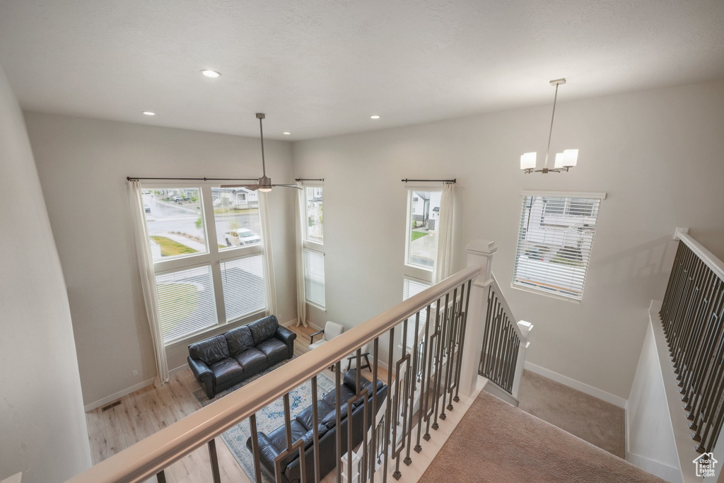 Stairs with baseboards, recessed lighting, plenty of natural light, and a chandelier