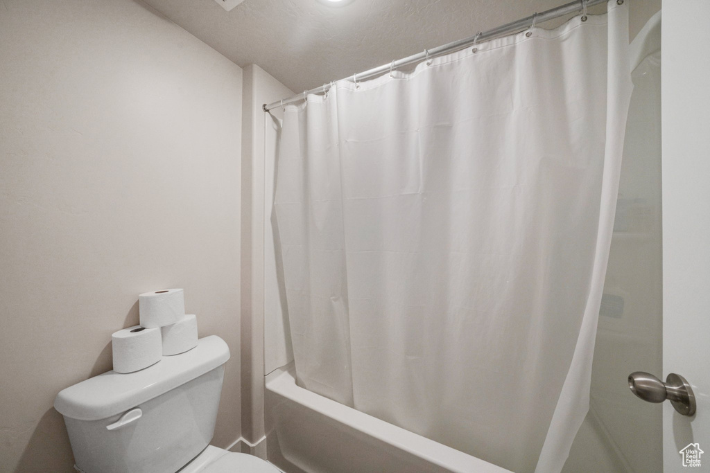 Full bathroom with shower / bath combo with shower curtain and toilet