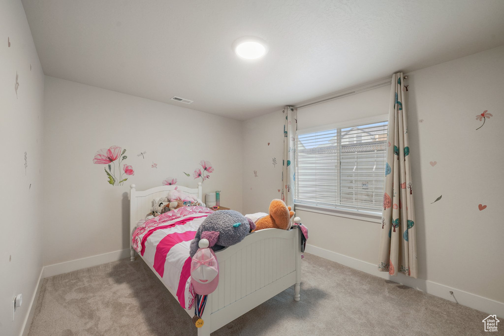 Carpeted bedroom with visible vents and baseboards