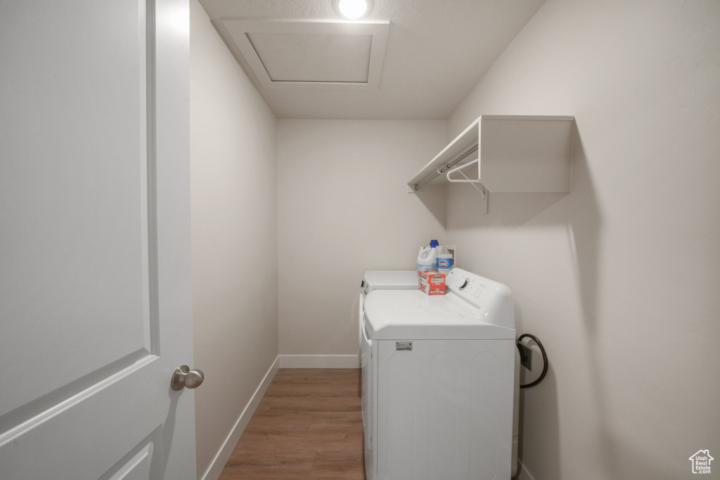 Laundry room featuring laundry area, light wood-style floors, baseboards, and separate washer and dryer