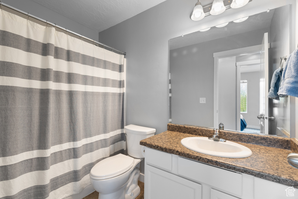 Full bathroom featuring vanity, a shower with curtain, and toilet