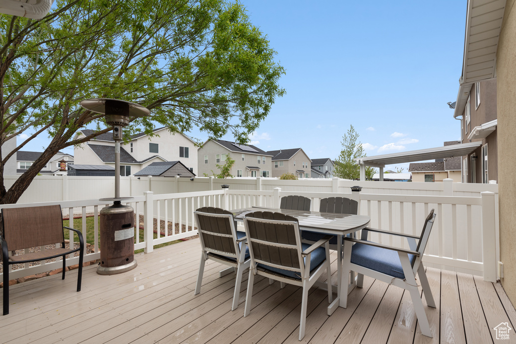 Deck with a residential view, fence, and outdoor dining space