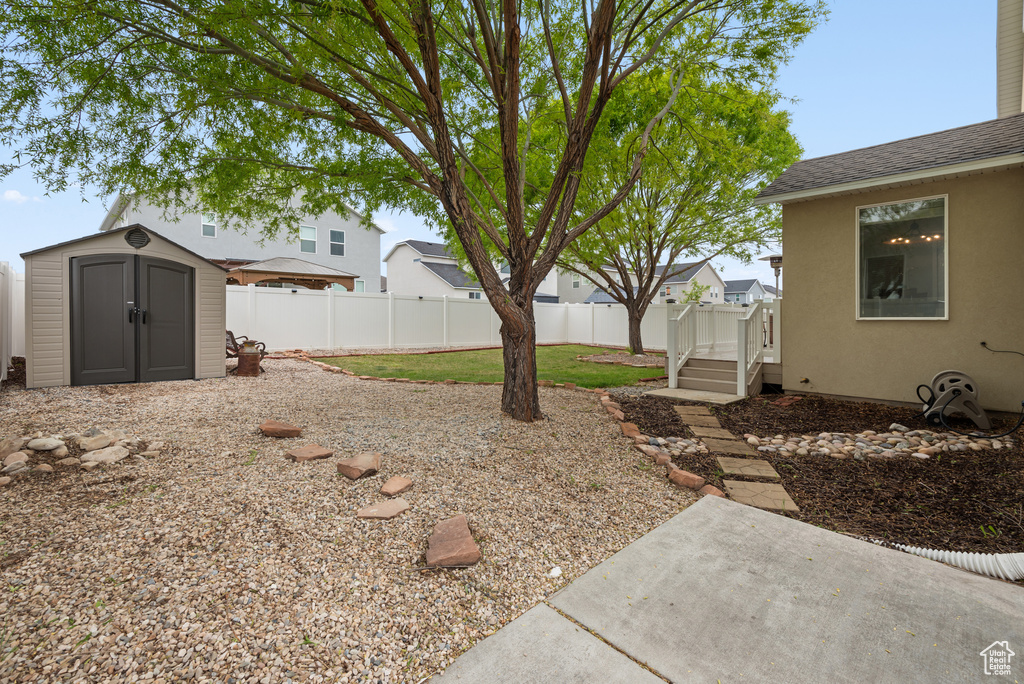 View of yard featuring a fenced backyard, an outbuilding, a patio area, and a storage shed