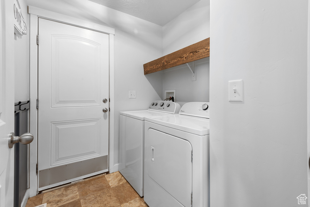 Laundry room featuring laundry area, stone finish flooring, and independent washer and dryer