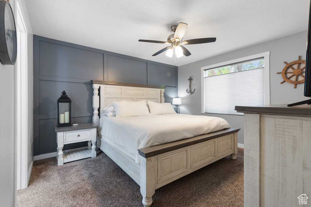 Bedroom with dark carpet and ceiling fan