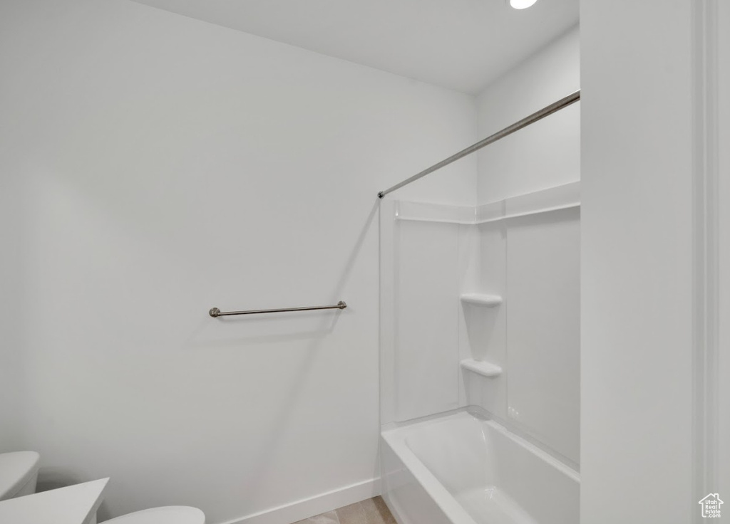 Full bath with baseboards, vanity, toilet, and bathing tub / shower combination