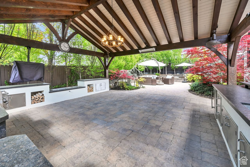 View of patio with fence, outdoor dining space, a gazebo, and exterior kitchen