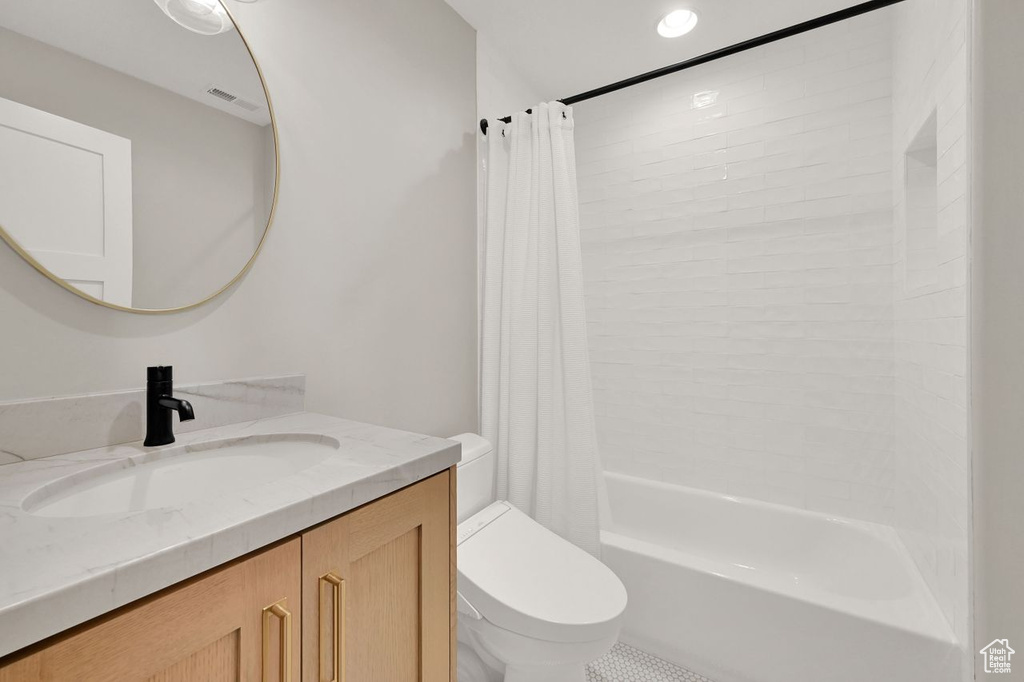Bathroom featuring shower / tub combo with curtain, vanity, toilet, recessed lighting, and visible vents