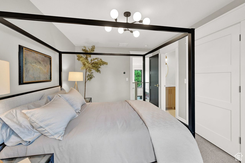 Bedroom with access to outside, lofted ceiling, a notable chandelier, and light carpet