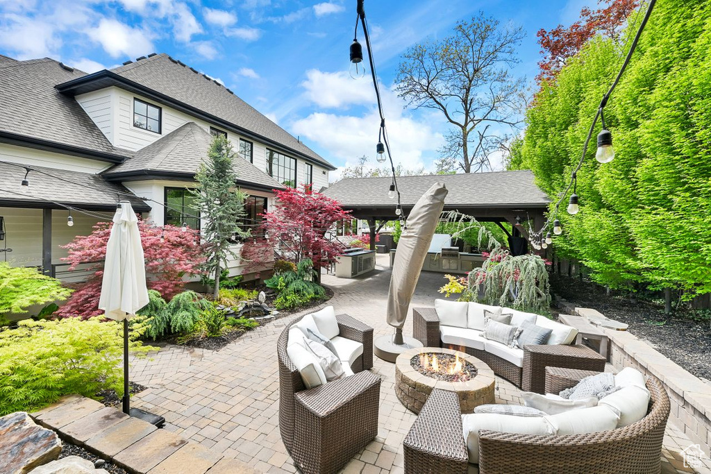 View of patio with an outdoor living space with a fire pit