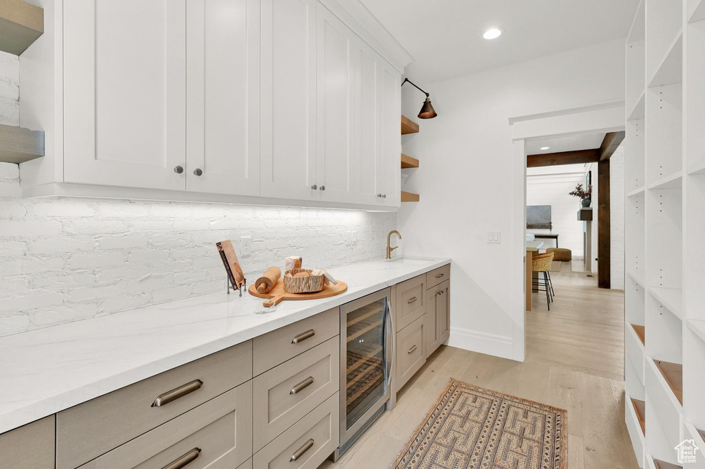 Bar featuring wine cooler, light wood-style floors, backsplash, and recessed lighting