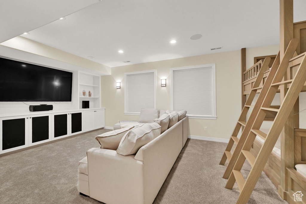 Carpeted living room featuring baseboards, recessed lighting, built in shelves, and visible vents