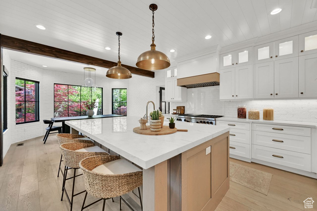 Kitchen featuring light wood-style floors, plenty of natural light, a kitchen island with sink, and recessed lighting