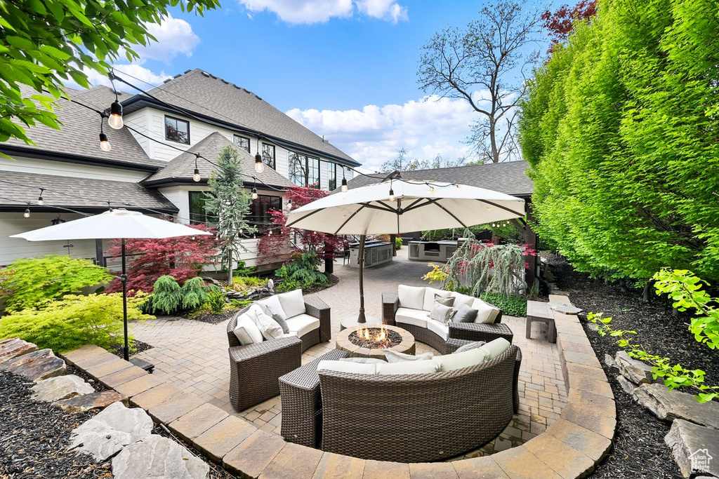 View of patio featuring an outdoor living space with a fire pit