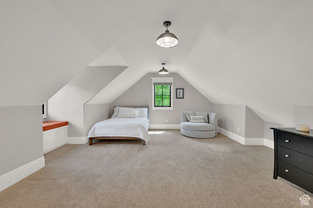 Carpeted bedroom featuring baseboards and vaulted ceiling