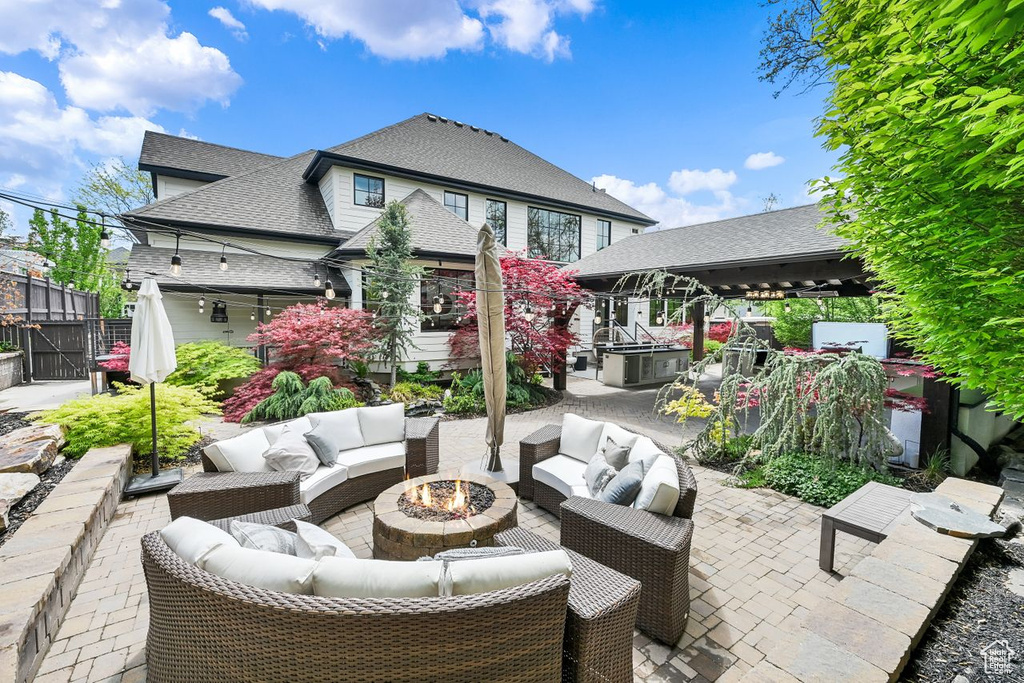 View of patio / terrace featuring a gazebo, an outdoor living space with a fire pit, and fence