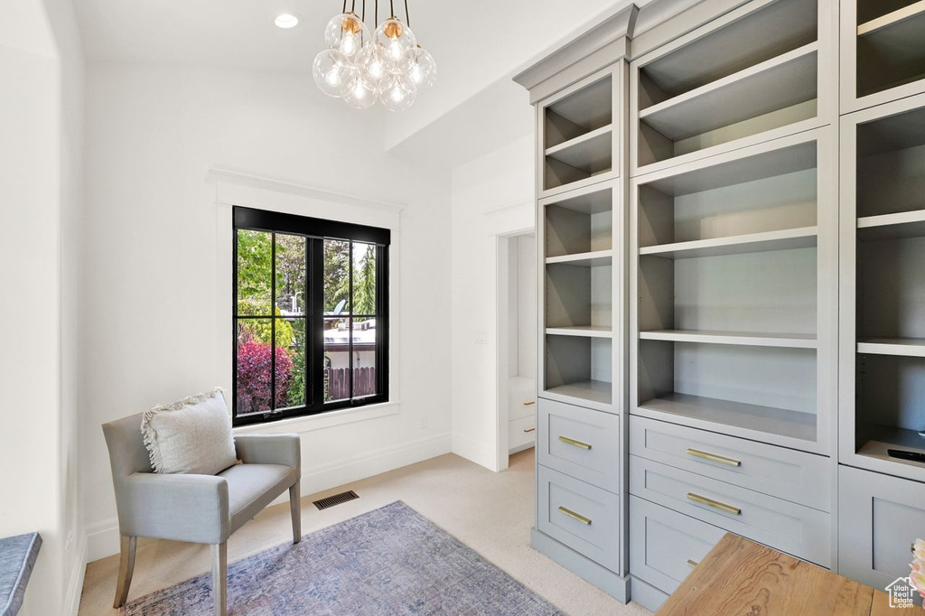 Walk in closet featuring visible vents, light colored carpet, and an inviting chandelier