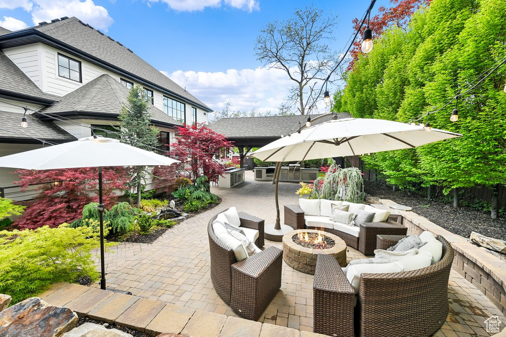 View of patio featuring an outdoor bar and an outdoor living space with a fire pit