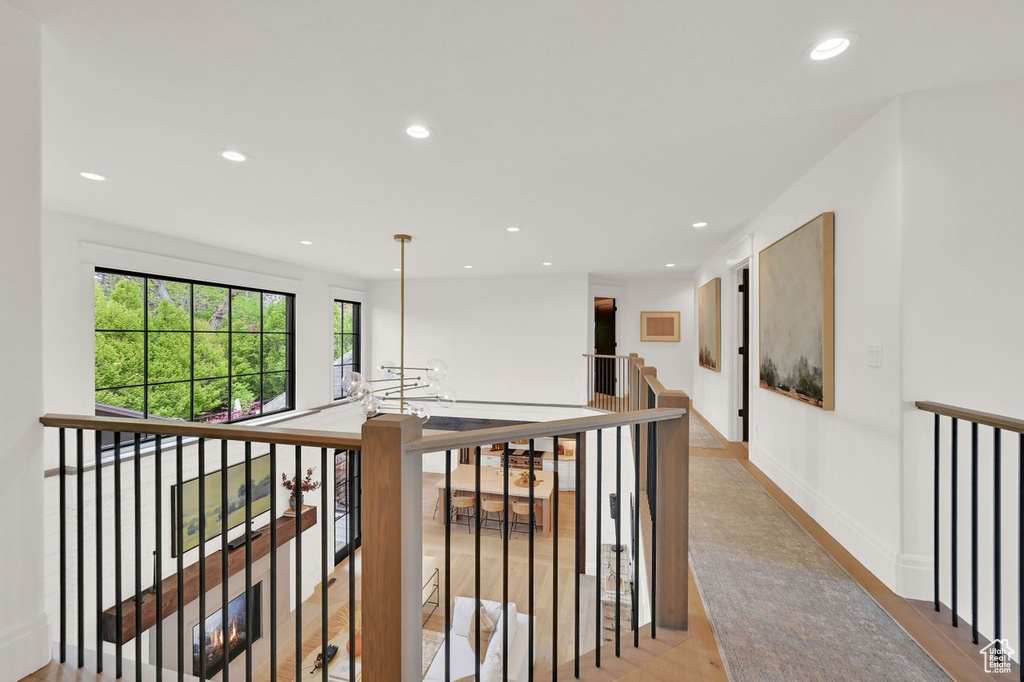 Corridor with recessed lighting, light wood-style flooring, and an upstairs landing