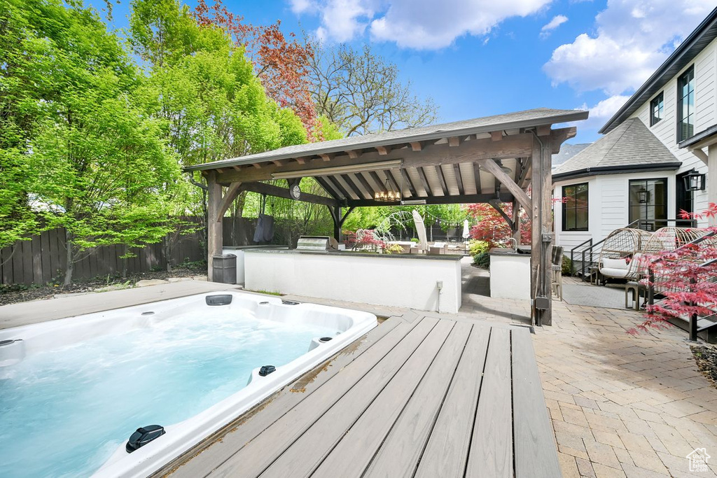 Wooden terrace with a gazebo, hot tub deck surround, a patio area, and fence
