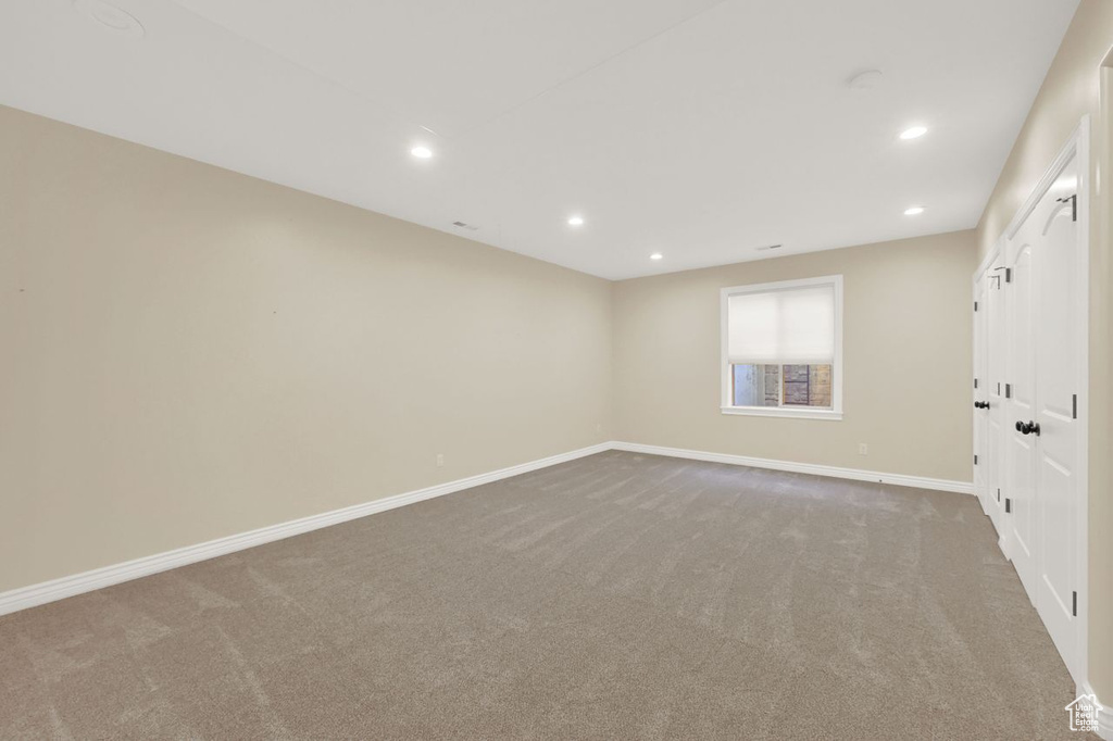 Carpeted spare room featuring baseboards and recessed lighting