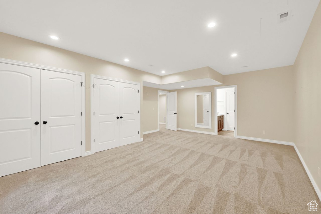 Interior space featuring light colored carpet, recessed lighting, baseboards, and visible vents