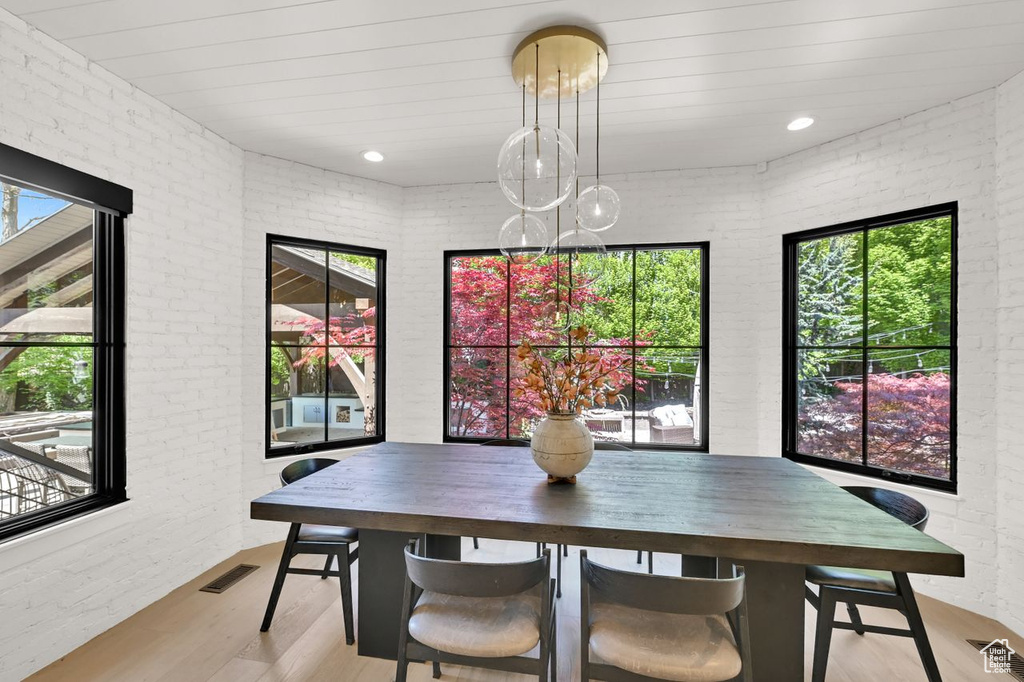 Dining area with light wood-type flooring, plenty of natural light, and visible vents