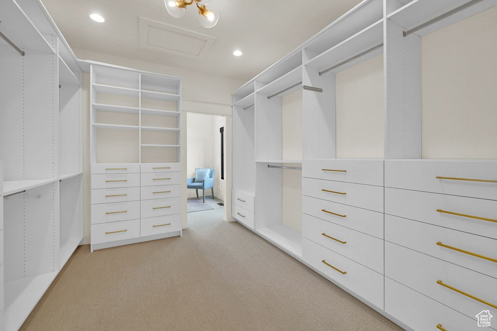 Walk in closet featuring attic access and light carpet