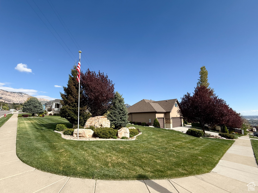 View of side of home with a lawn and a garage