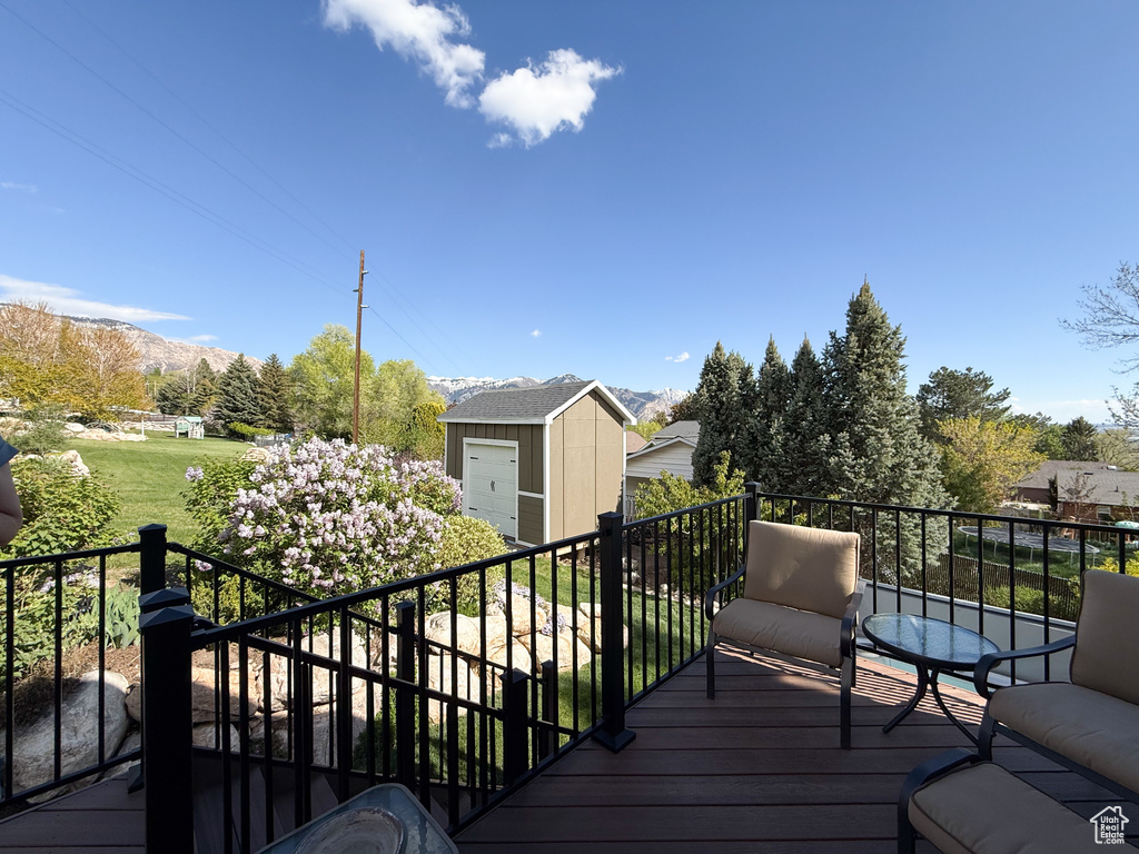 Deck featuring an outbuilding, a mountain view, and a shed