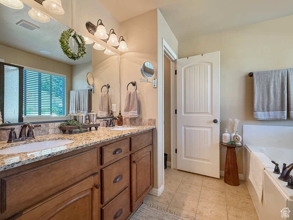 Full bathroom featuring double vanity, tile patterned floors, visible vents, and a sink