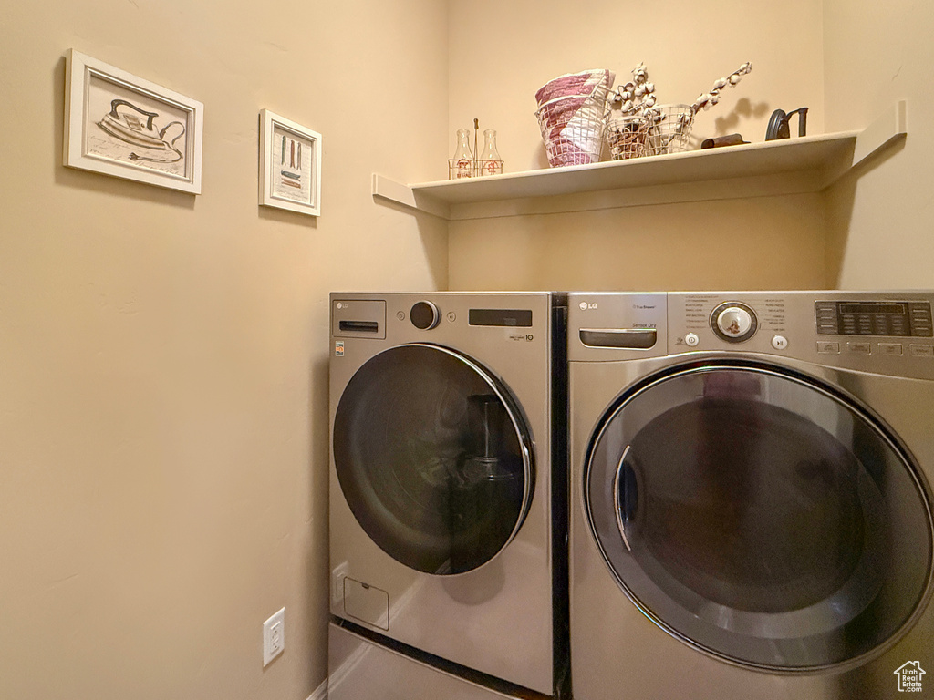 Clothes washing area featuring independent washer and dryer and laundry area