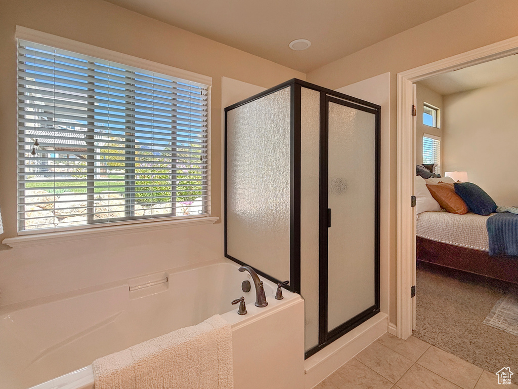 Full bathroom with a stall shower, connected bathroom, a bath, and tile patterned floors
