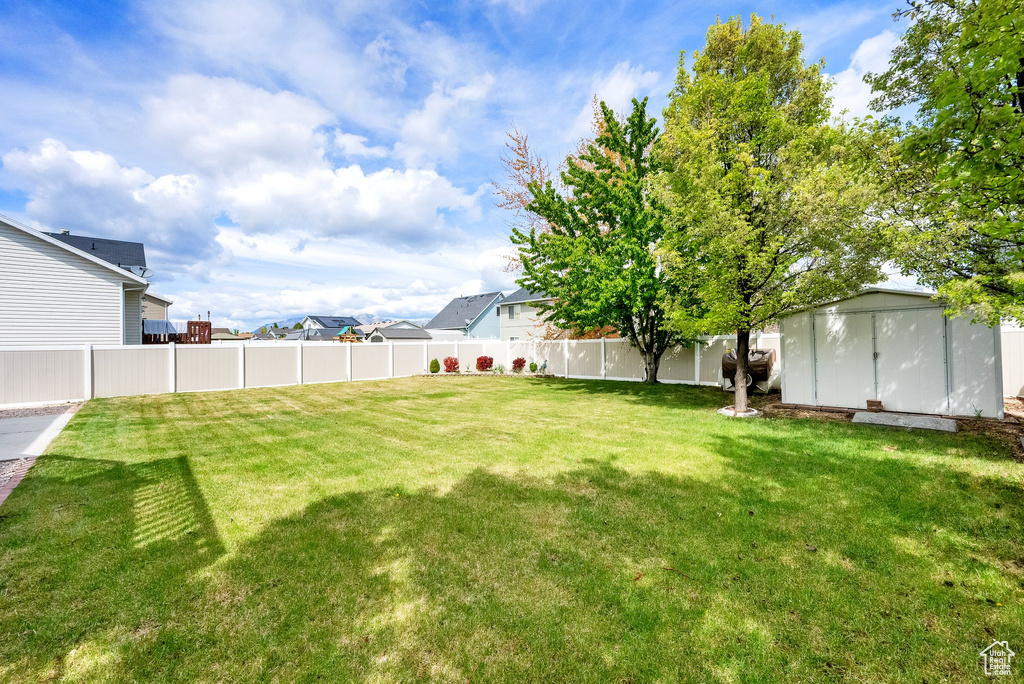 View of yard with a fenced backyard, an outbuilding, and a storage shed