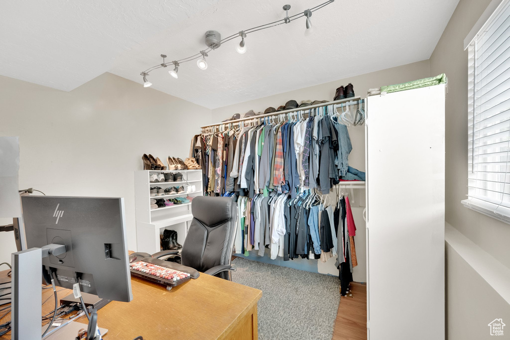 Walk in closet with wood finished floors