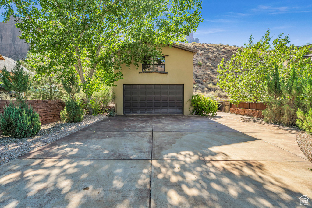 Garage featuring fence and concrete driveway